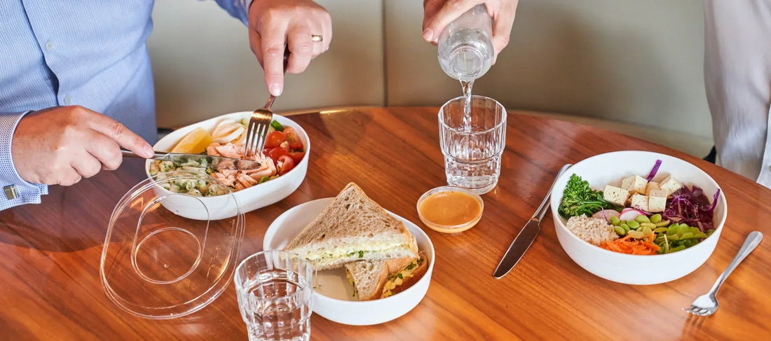 Reusable Hu bowls used for workplace dining with sandwiches, salads, and fresh meals, reducing single-use packaging in contract catering.