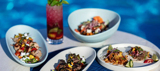 Poolside table setting with Dalebrook Pigment and Hoxton serveware, featuring plated dishes and drinks beside a swimming pool.