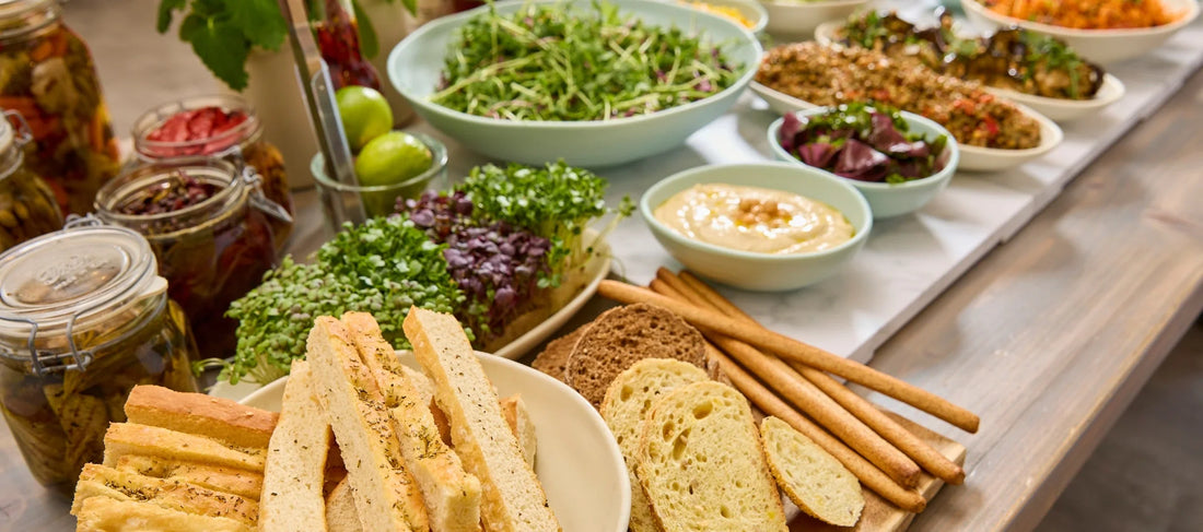 Retail salad bar display with fresh salads, hummus and grain dishes presented in Dalebrook bowls and deli counter serveware.