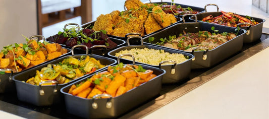 Selection of hot counter dishes presented in Ore trays, including sliced meats, roasted vegetables, and beets, arranged in a seamless GN grid for professional hot food service