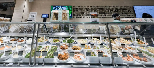 Wide shot of the Spinneys DAFZ salad bar featuring Dalebrook bowls and trays, displaying fresh salads, sides and ready to eat dishes in a clean and cohesive counter layout.
