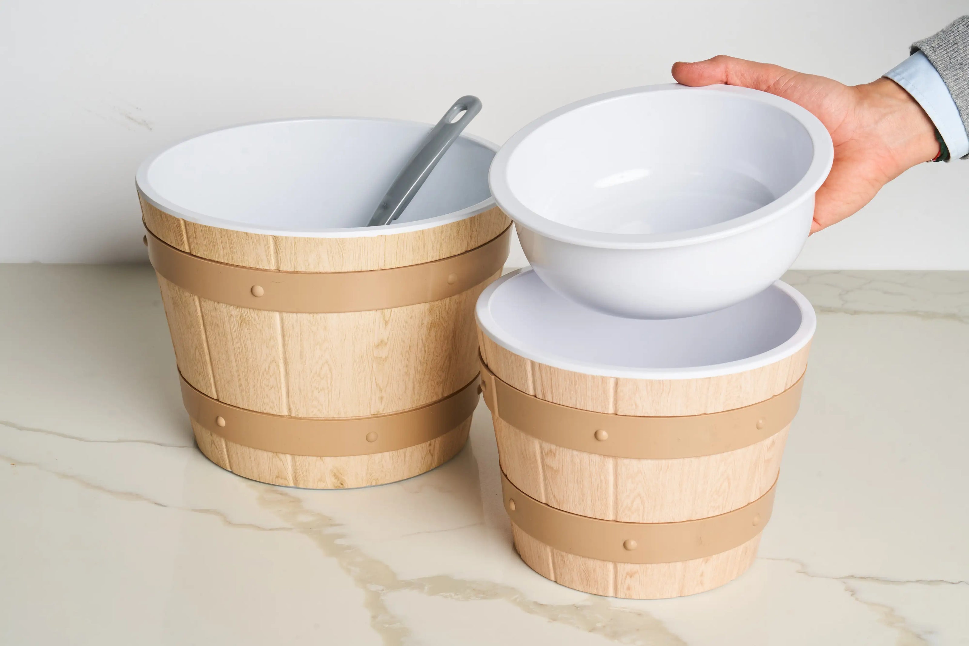 Wood-effect barrel bowl with removable white melamine insert, designed to reduce capacity and minimise food waste while maintaining a full display appearance.