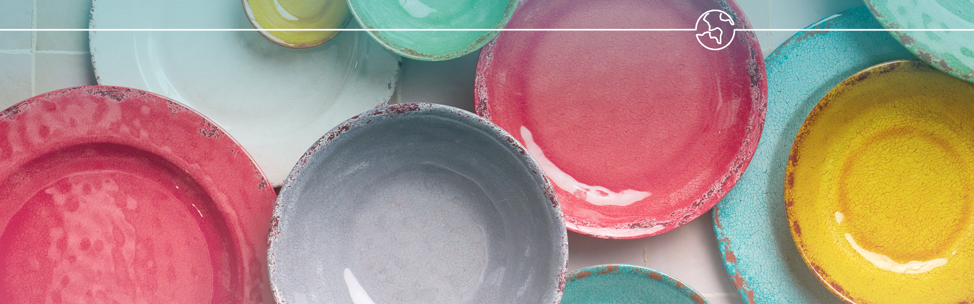 Colourful Casablanca plates and bowls arranged on a tiled surface with a white line and globe icon overlay.